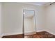 Empty bedroom showcasing hardwood floors and a mirror standing against a pale colored wall at 1121 Myrtle Ave # 72, Charlotte, NC 28203
