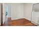 Empty bedroom featuring hardwood floors, neutral walls, and doorway to another room at 1121 Myrtle Ave # 72, Charlotte, NC 28203