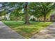 Lush green common area with mature trees and sidewalks around a stately apartment complex at 1121 Myrtle Ave # 72, Charlotte, NC 28203
