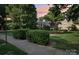 Well-maintained common area featuring manicured shrubs, green lawn, and mature shade trees near sidewalk at 1121 Myrtle Ave # 72, Charlotte, NC 28203