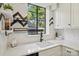 Stylish kitchen sink with modern black faucet and white quartz counters, and elegant herringbone backsplash at 1121 Myrtle Ave # 72, Charlotte, NC 28203