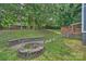 Expansive backyard featuring a stone fire pit, wooden deck, and lush greenery at 11619 Rimrock Canyon Dr, Charlotte, NC 28226