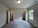 Bedroom showcasing a door to the bathroom and walk in closet with neutral walls, carpeted floor and natural light at 1312 7Th St, Statesville, NC 28677