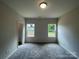 Inviting bedroom showcasing two windows, neutral walls and plush gray carpeting at 1312 7Th St, Statesville, NC 28677