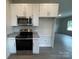 Modern kitchen boasts stainless steel appliances, granite countertops, and sleek white cabinetry at 1312 7Th St, Statesville, NC 28677