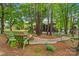 Lush backyard featuring a firepit, mature trees, screened porch, and outdoor dining area at 149 Harbor Landing Dr, Mooresville, NC 28117