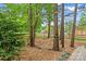 Beautiful backyard with lush landscaping, mature trees, wood fencing, and a quaint swing set at 149 Harbor Landing Dr, Mooresville, NC 28117