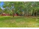 Expansive backyard showcasing mature trees, a screened porch, and multiple outdoor seating areas at 149 Harbor Landing Dr, Mooresville, NC 28117