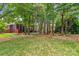 Spacious backyard featuring lush lawn, firepit area, mature trees, and screened porch at 149 Harbor Landing Dr, Mooresville, NC 28117