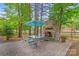Backyard with stone fireplace, patio dining set, umbrella and trees for shade at 149 Harbor Landing Dr, Mooresville, NC 28117