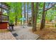 Lush backyard with a grill, stone fireplace, patio dining set, and mature trees for shade at 149 Harbor Landing Dr, Mooresville, NC 28117