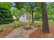 Backyard firepit area with stone surround and green Adirondack chairs creating an inviting outdoor space at 149 Harbor Landing Dr, Mooresville, NC 28117