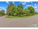 Landscaped corner lot featuring lush green grass and mature trees, enhancing the property's curb appeal at 149 Harbor Landing Dr, Mooresville, NC 28117