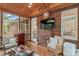 Cozy sunroom with brick accent wall, comfortable seating, and glass table for enjoying indoor-outdoor living at 149 Harbor Landing Dr, Mooresville, NC 28117