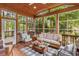 Relaxing sunroom filled with natural light from surrounding windows, comfortable seating, and wood floors at 149 Harbor Landing Dr, Mooresville, NC 28117