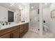 Modern bathroom with double vanity, wood cabinets, stylish fixtures, and a sleek glass-enclosed shower at 158 Mattoon St, Charlotte, NC 28216