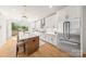 Bright kitchen features white cabinetry, stainless appliances, large island and pendant lighting at 158 Mattoon St, Charlotte, NC 28216