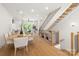 Bright open-concept living and dining area featuring modern decor, wooden floors, and staircase with black railings at 158 Mattoon St, Charlotte, NC 28216
