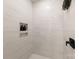 Elegant walk-in shower with floor-to-ceiling marble-look tiles, a built-in niche, and a modern black showerhead at 158 Mattoon St, Charlotte, NC 28216
