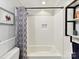 Clean bathroom featuring a tiled shower/tub combo and simple shelving at 1605 Allen St, Charlotte, NC 28205
