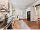 Bright eat-in kitchen featuring stainless steel appliances, black countertops and wood flooring at 1605 Allen St, Charlotte, NC 28205