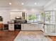 Charming kitchen features stainless steel appliances, white cabinetry, and a farmhouse sink at 1605 Allen St, Charlotte, NC 28205