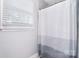Bright bathroom featuring a white bathtub with a shower and a window with blinds at 16433 Grapperhall Dr, Huntersville, NC 28078