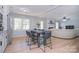 Open-concept view of the kitchen with white cabinets, stainless appliances, and a dining table at 16433 Grapperhall Dr, Huntersville, NC 28078