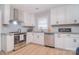 Updated kitchen with white cabinets, stainless steel appliances, granite countertops, and contemporary fixtures at 16433 Grapperhall Dr, Huntersville, NC 28078