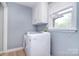Laundry room featuring a large window, a washing machine and dryer set, and overhead cabinets at 16433 Grapperhall Dr, Huntersville, NC 28078