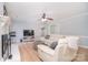 Bright living room with a ceiling fan, fireplace, and a comfortable white leather sofa at 16433 Grapperhall Dr, Huntersville, NC 28078