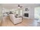 Open-concept living room featuring a fireplace, wood floors, and a view into the modern kitchen at 16433 Grapperhall Dr, Huntersville, NC 28078