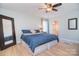 Comfortable bedroom featuring hardwood floors, neutral walls, ceiling fan, and an attached bathroom at 16433 Grapperhall Dr, Huntersville, NC 28078
