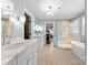 Elegant bathroom featuring dual vanities, a glass-enclosed shower, and a soaking tub at 236 Wales Ave, Charlotte, NC 28209