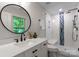 Modern bathroom with a circular mirror, sleek vanity, and walk-in shower with stylish tile at 236 Wales Ave, Charlotte, NC 28209