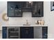 Modern kitchen with navy cabinets, quartz countertops, stainless steel appliances and wine fridge at 236 Wales Ave, Charlotte, NC 28209