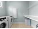 Well-organized laundry room equipped with washer, dryer, and storage shelves at 236 Wales Ave, Charlotte, NC 28209