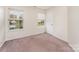 Well-lit bedroom featuring neutral walls, carpet flooring, and natural light from two windows at 2903 Rockingham Sw Ct, Concord, NC 28025