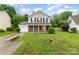 Welcoming two-story home with a gray exterior, brick details, a green lawn, and a practical single-car garage at 2903 Rockingham Sw Ct, Concord, NC 28025