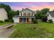 Charming two-story home featuring gray siding, brick accents, a well-manicured lawn, and a single-car garage at 2903 Rockingham Sw Ct, Concord, NC 28025