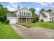 Inviting two-story home with a brick facade, gray siding, a well-kept lawn, and a convenient single-car garage at 2903 Rockingham Sw Ct, Concord, NC 28025