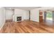 Open-concept living room showcasing wood-look floors, a fireplace, and seamless transition to dining and staircase at 2903 Rockingham Sw Ct, Concord, NC 28025