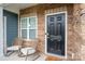 Welcoming front door with brick surround and rocking chairs on the covered porch at 348 Zocalo Dr, Gastonia, NC 28056