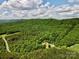A scenic aerial view reveals a quaint cabin nestled amongst rolling hills covered in dense forest at 362 Sandburg Rd, Union Grove, NC 28689
