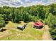 An aerial view of a charming cabin with a red roof surrounded by lush greenery at 362 Sandburg Rd, Union Grove, NC 28689