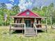 Charming cabin exterior with a cozy porch, a wooden facade and an American flag at 362 Sandburg Rd, Union Grove, NC 28689