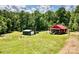 Exterior view of a charming cabin with a red roof and a green storage shed at 362 Sandburg Rd, Union Grove, NC 28689