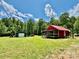 Charming red home with a covered porch and a metal storage shed, all on a well-maintained lawn at 362 Sandburg Rd, Union Grove, NC 28689