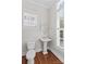Well-lit bathroom features a classic pedestal sink, toilet, and shuttered windows at 376 Delburg St, Davidson, NC 28036