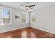 Bedroom featuring hardwood floors, a ceiling fan, and natural light from three windows at 376 Delburg St, Davidson, NC 28036